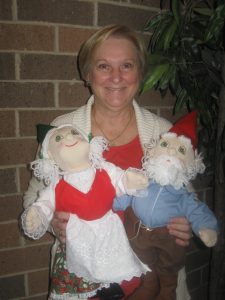 Gnome doll creator, Sally Susner, holds the twin soft-sculpture dolls to be raffled.